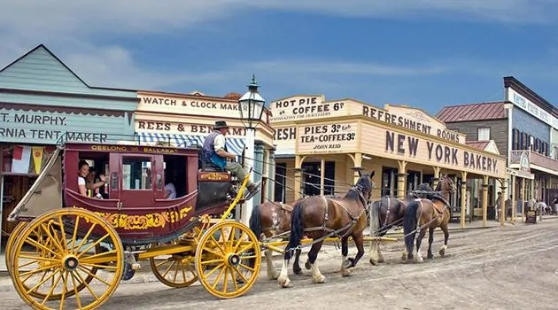 A horse drawn carriage with horses Description automatically generated