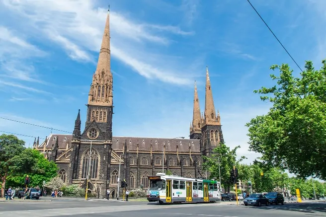 A church with a train on the street Description automatically generated with medium confidence